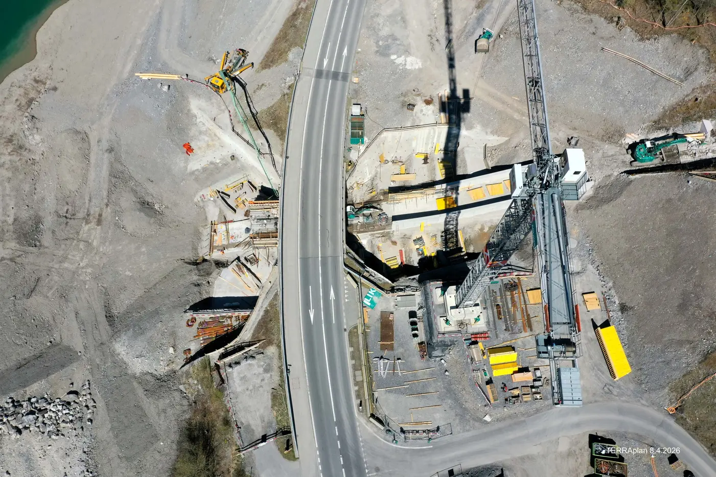 Bauplatz mit schwerem Gerät, Straßen und Wasser in der Nähe.