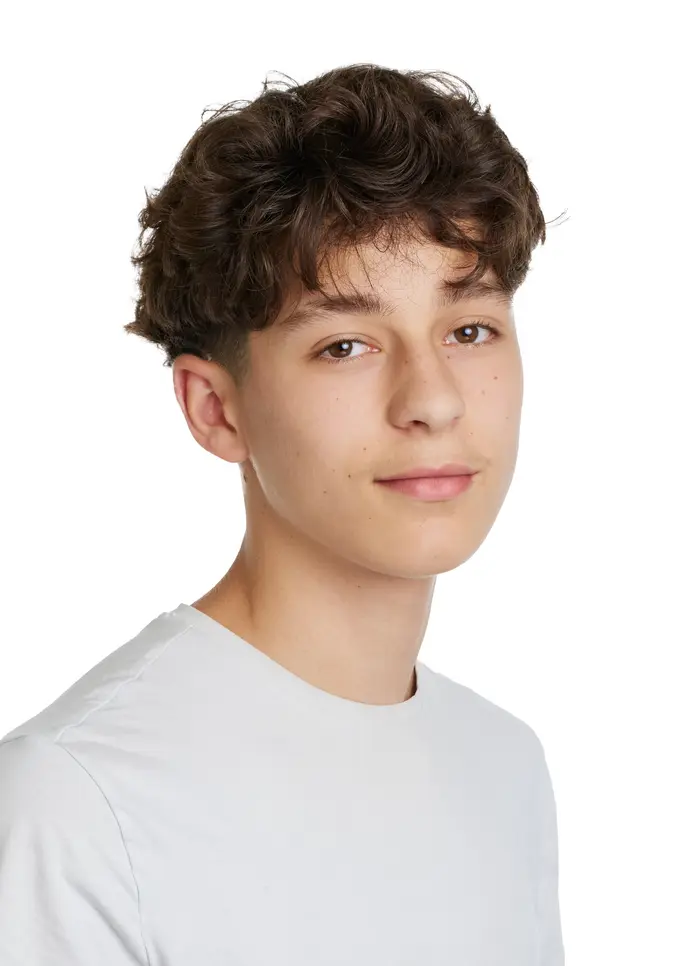 Junger Mann mit lockigem, braunem Haar und hellem T-Shirt, lächelt leicht.