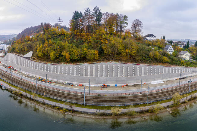 Die neue Reussthalmauer ist gebaut und das Schutzgerüst wurde entfernt. Am Fuss der Mauer sind die Strassenbauarbeiten bereits im vollen Gange. Drohnenaufnahme vom 05.11.2020.