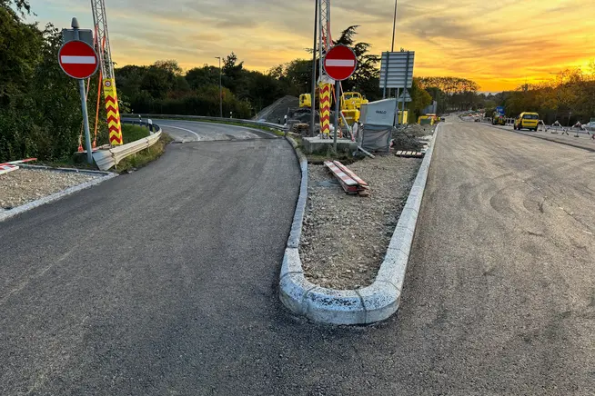Nouvelle route avec panneaux de circulation et coucher de soleil en arrière-plan.